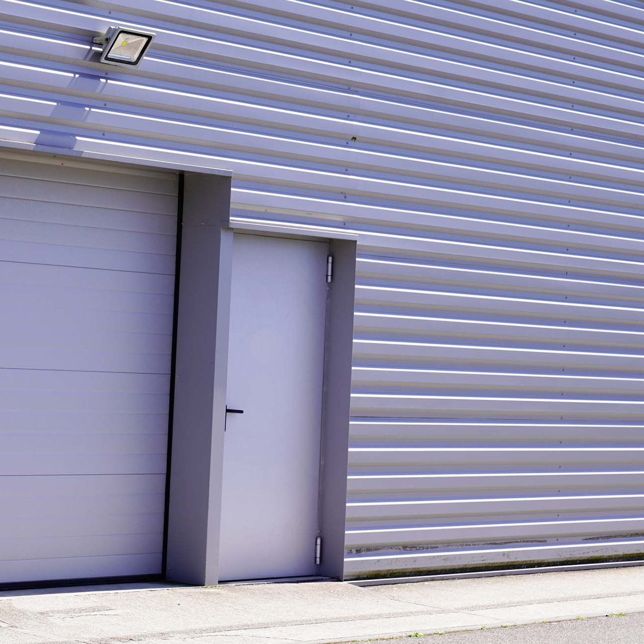 Storage units with white roller shutter doors in industrial area